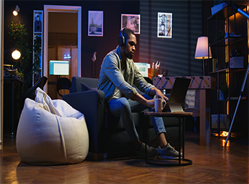 mannlicher freelancer der zu hause multitasking macht und aufgaben mit musik auf einem headset lost.jpg